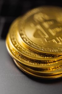Close-up of a stack of shiny gold bitcoins on a computer keyboard, symbolizing digital currency.